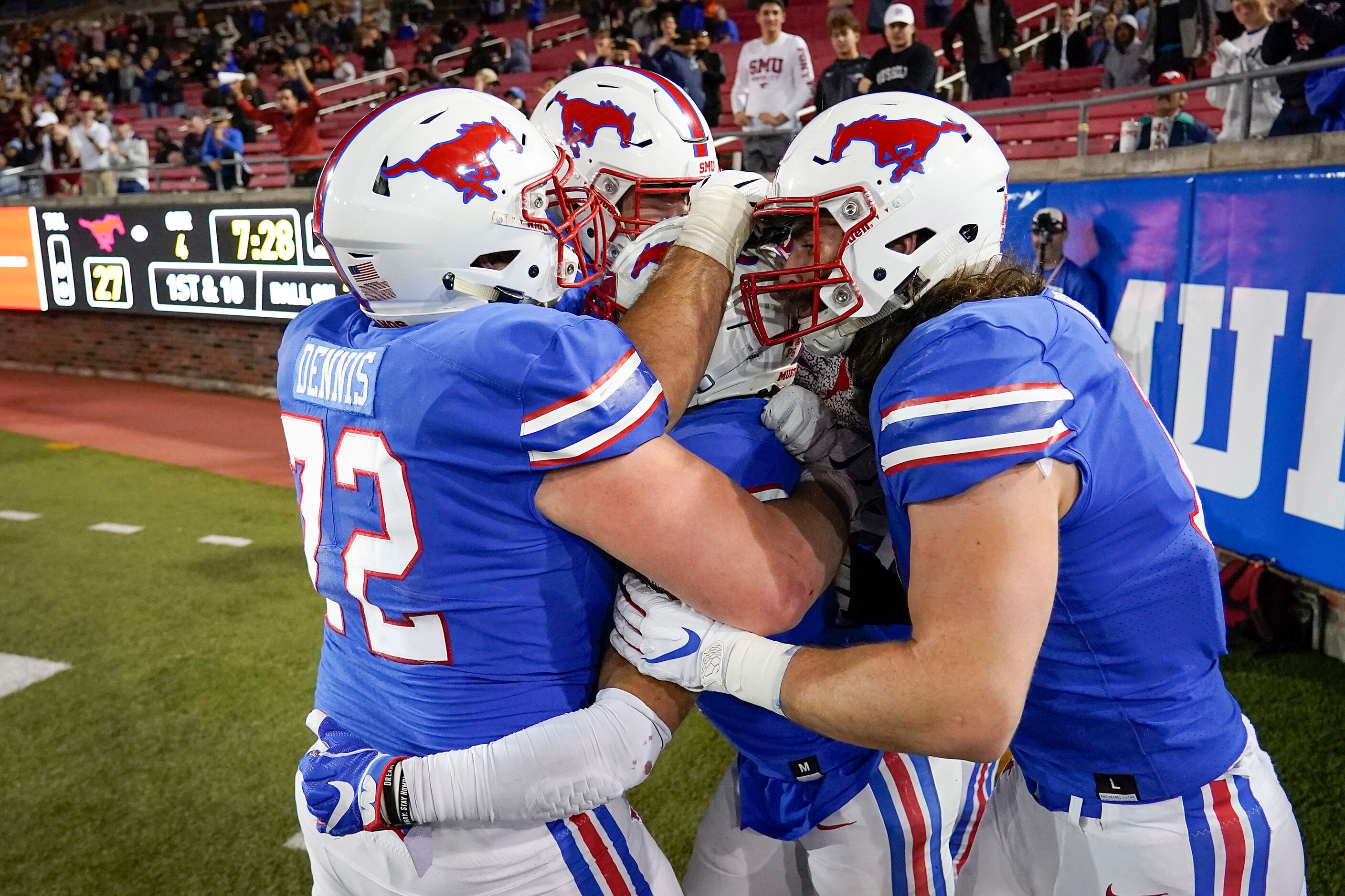 SMU players mob running back Xavier Jones (center) after he scoree on a 25-yard touchdown...