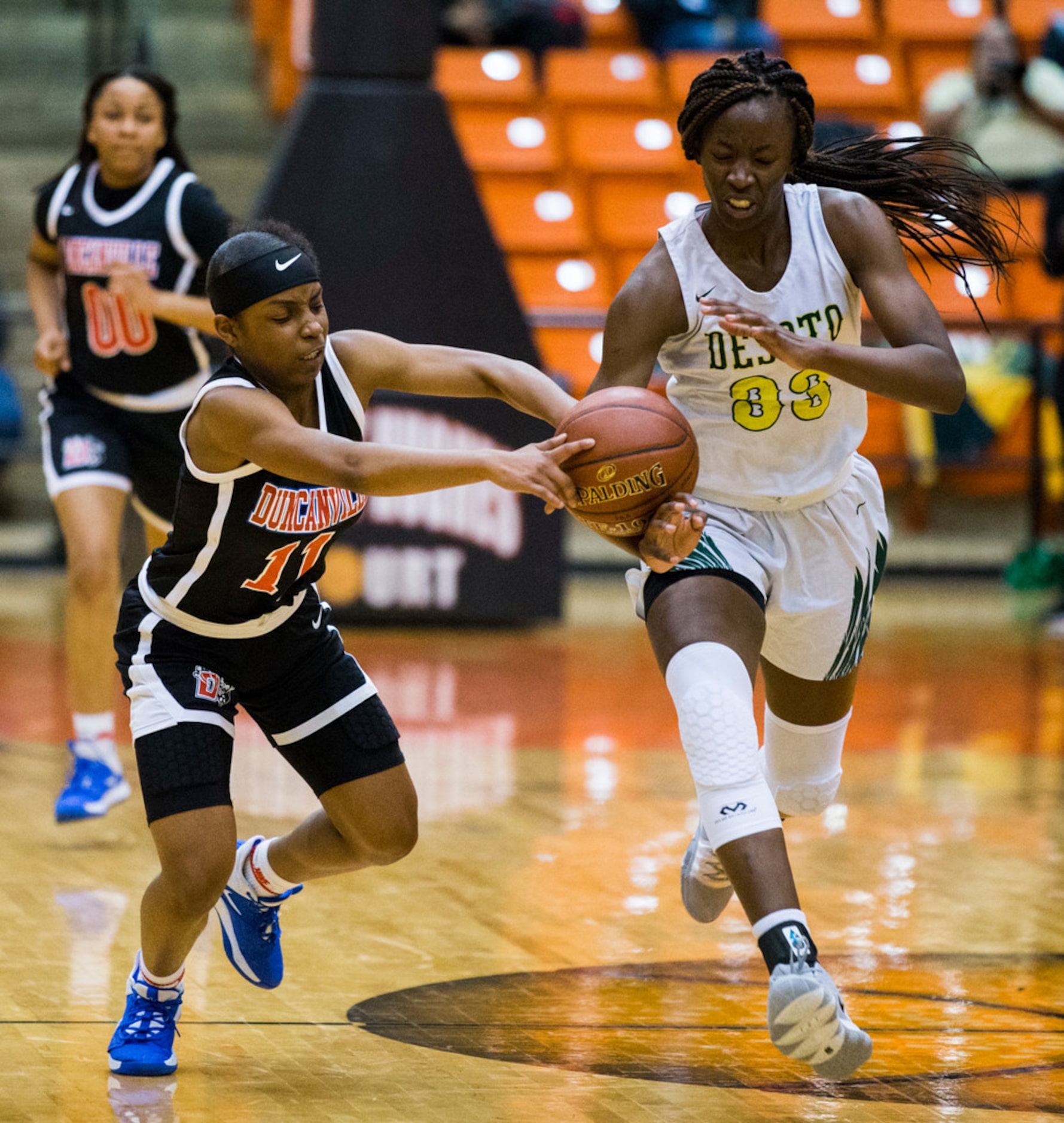 Duncanville's Tristen Taylor (11) and DeSoto's Amina Muhammad (33) reach for a loose ball...