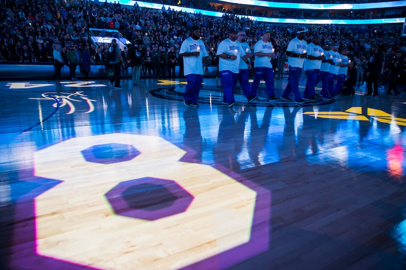 Mavs Maniacs hold candles during a tribute to former Los Angeles Laker Kobe Bryant and his...