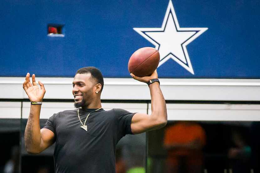 Dallas Cowboys wide receiver Dez Bryant tosses a football on the sidelines during the team's...