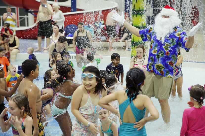 Santa Claus gets splashed by young swimmers at the Don Rodenbaugh Natatorium in Allen in...