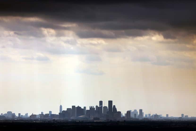 Lingering light rain falls near downtown the Houston, Texas skyline, Wednesday afternoon,...