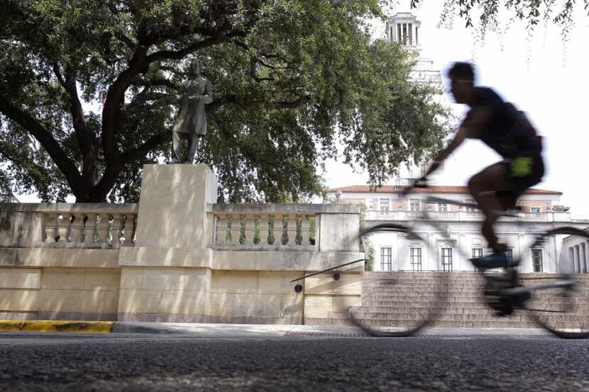 A cyclist passes a statue of Confederate President Jefferson Davis on the University of...