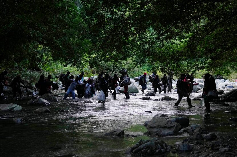 ARCHIVO - Migrantes cruzan el río Acandi en Acandi, Colombia, el 15 de septiembre de 2021,...