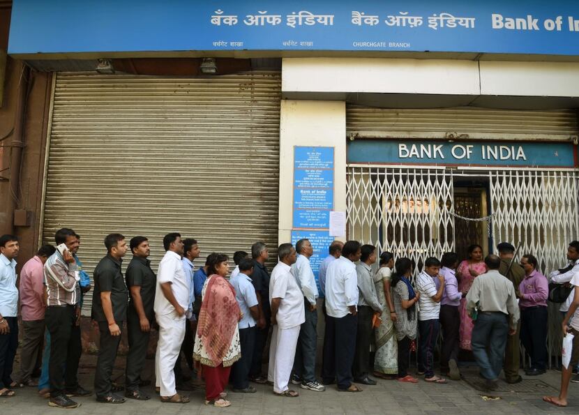 Indians queue up outside the Bank of India branch to deposit and exchange 500 and 1000...