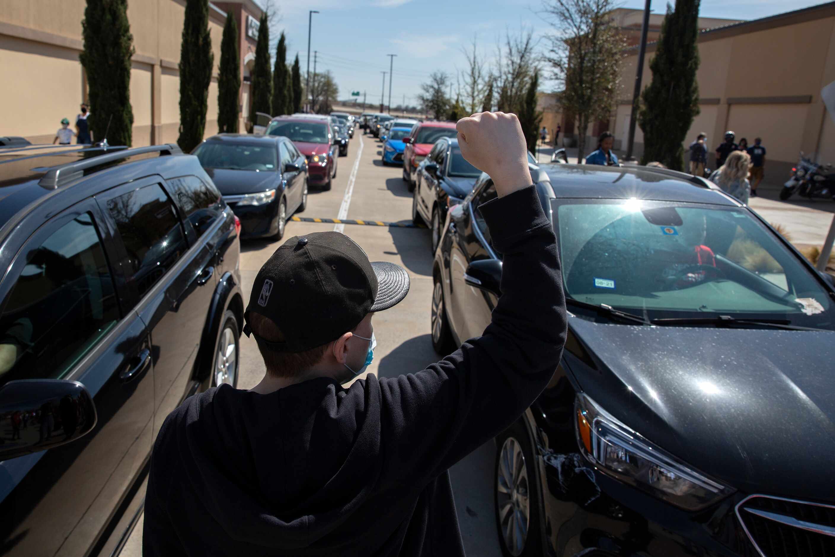 Max Bolen III puts up a fist towards the backed up traffic into the Allen Outlets on Sunday,...