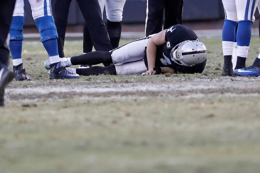 Oakland Raiders quarterback Derek Carr (4) remains on the field after an injury during the...