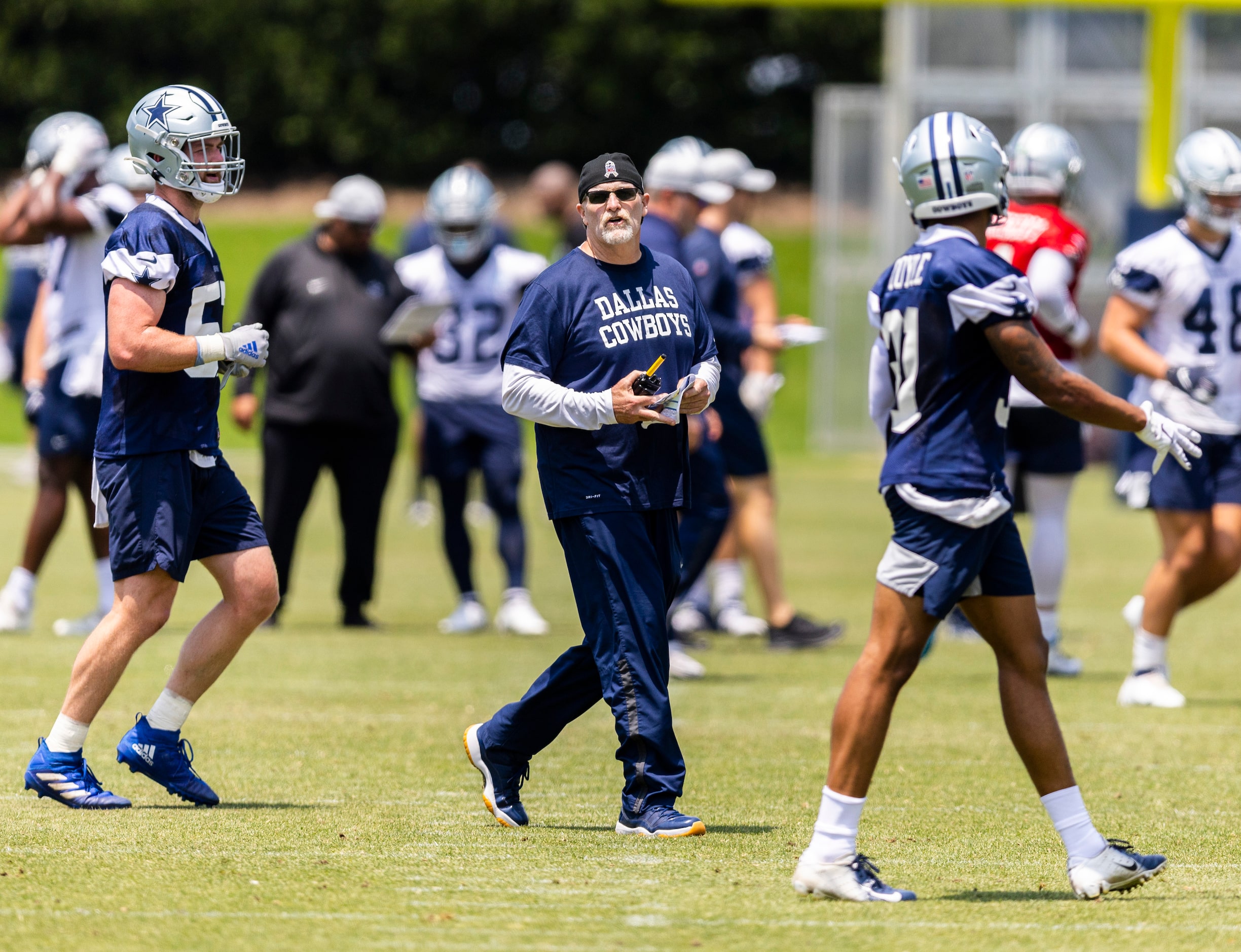 Dallas Cowboys Defensive Coordinator Dan Quinn, center, coaches during practice at The Star...