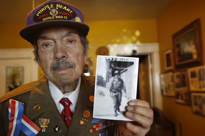 WWII veteran Lupe Valderas, photographed with a photo of himself while deployed in Germany,...