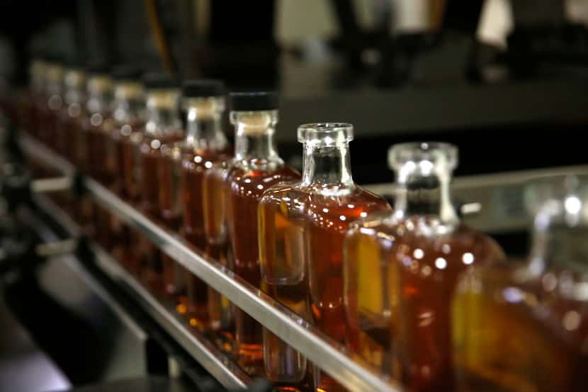 Bottles of Devils River Whiskey move through an assembly line at a bottling facility in...