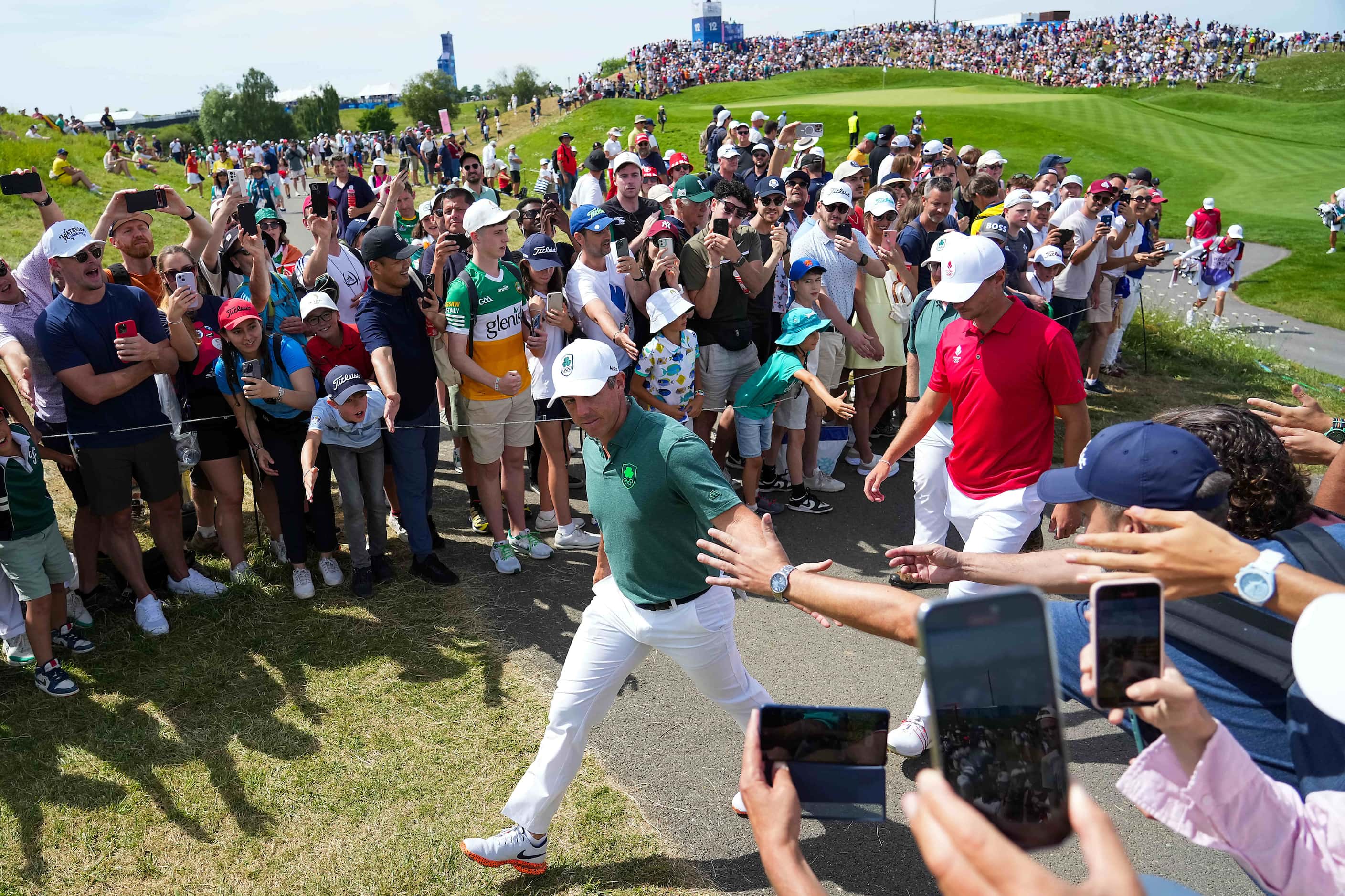 Fans reach out to Rory McIlroy of Ireland as he walks between holes during the final round...