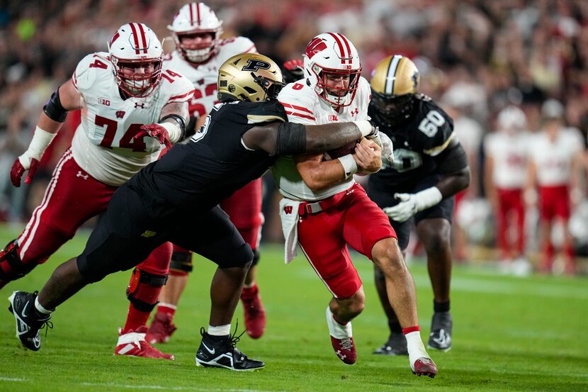 FILE - Wisconsin quarterback Tanner Mordecai (8) is tackled by then-Purdue linebacker Nic...