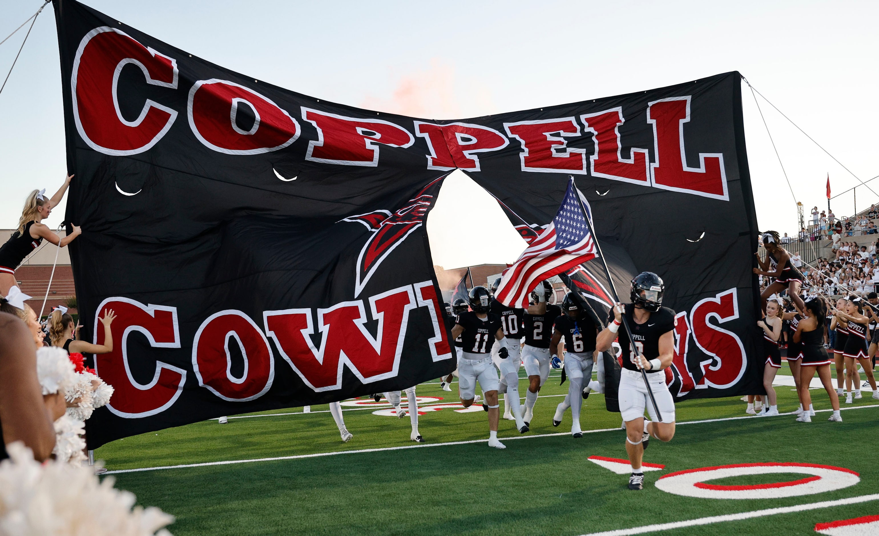 Coppell’s players run onto the field before a high school football game against Hebron,...