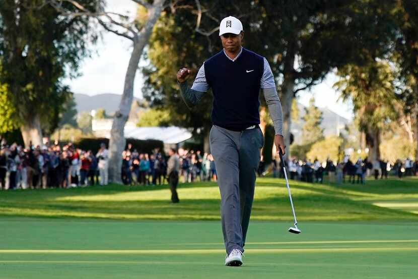 Tiger Woods fist pumps after making a birdie putt on the 13th hole during the third round of...