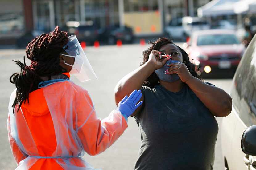 Lashara Allen (left), medical assistant helps as Charla Chappell of Dallas self-administers...