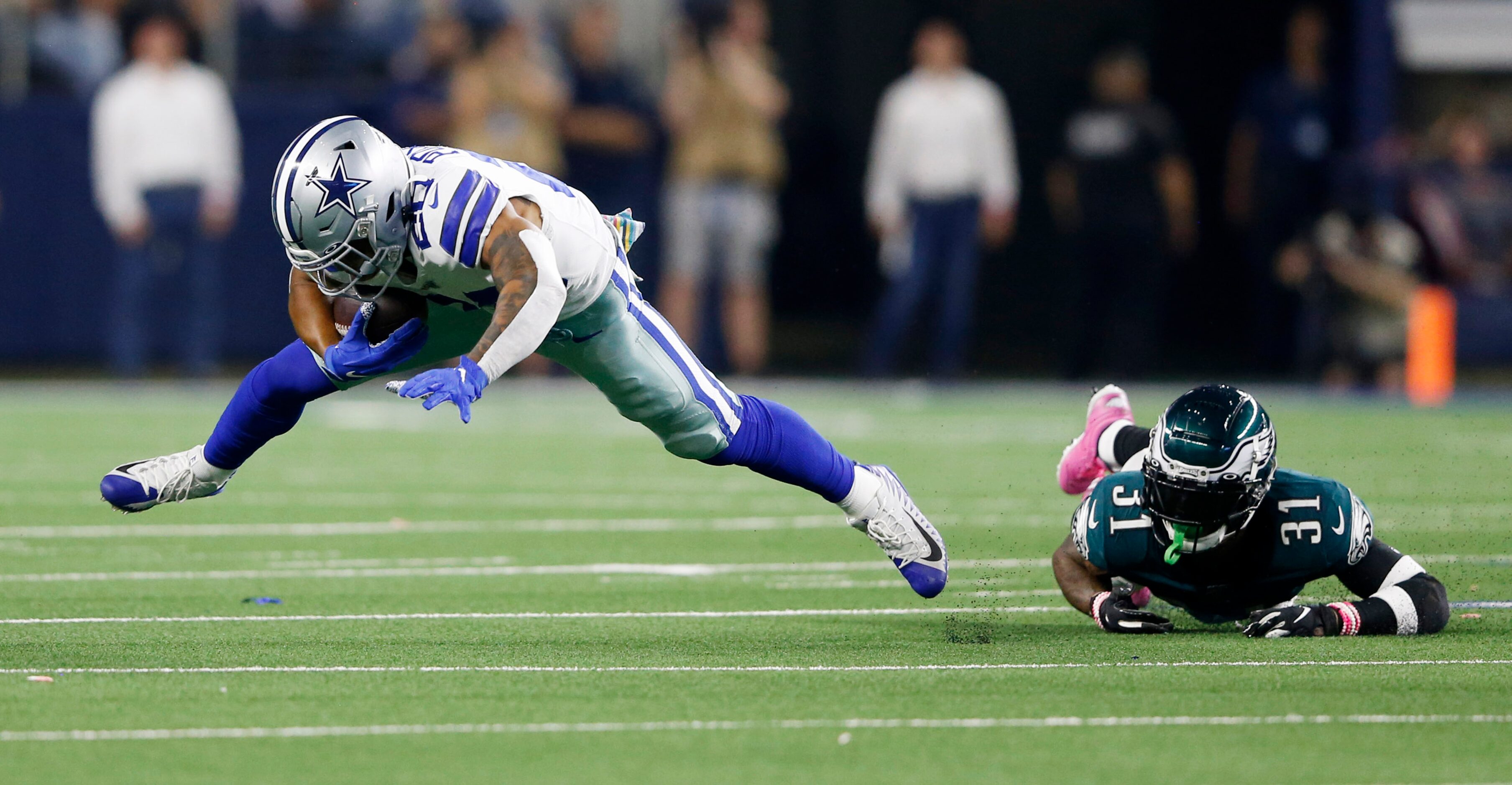 Dallas Cowboys running back Tony Pollard (20) stays up after getting tripped by Philadelphia...