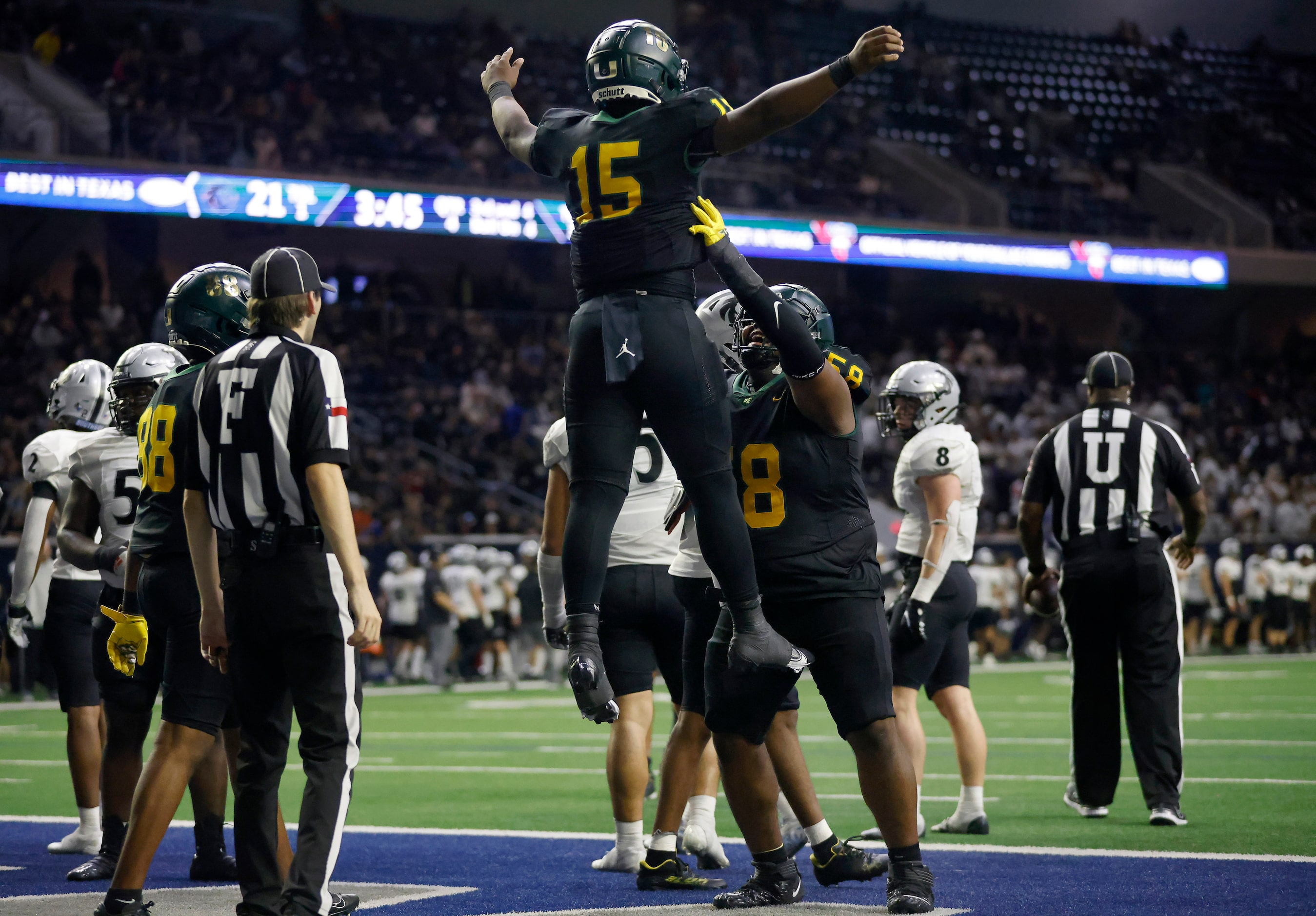 DeSoto quarterback Darius Bailey (15) is hoisted into the air by center Leon Brigham (58)...