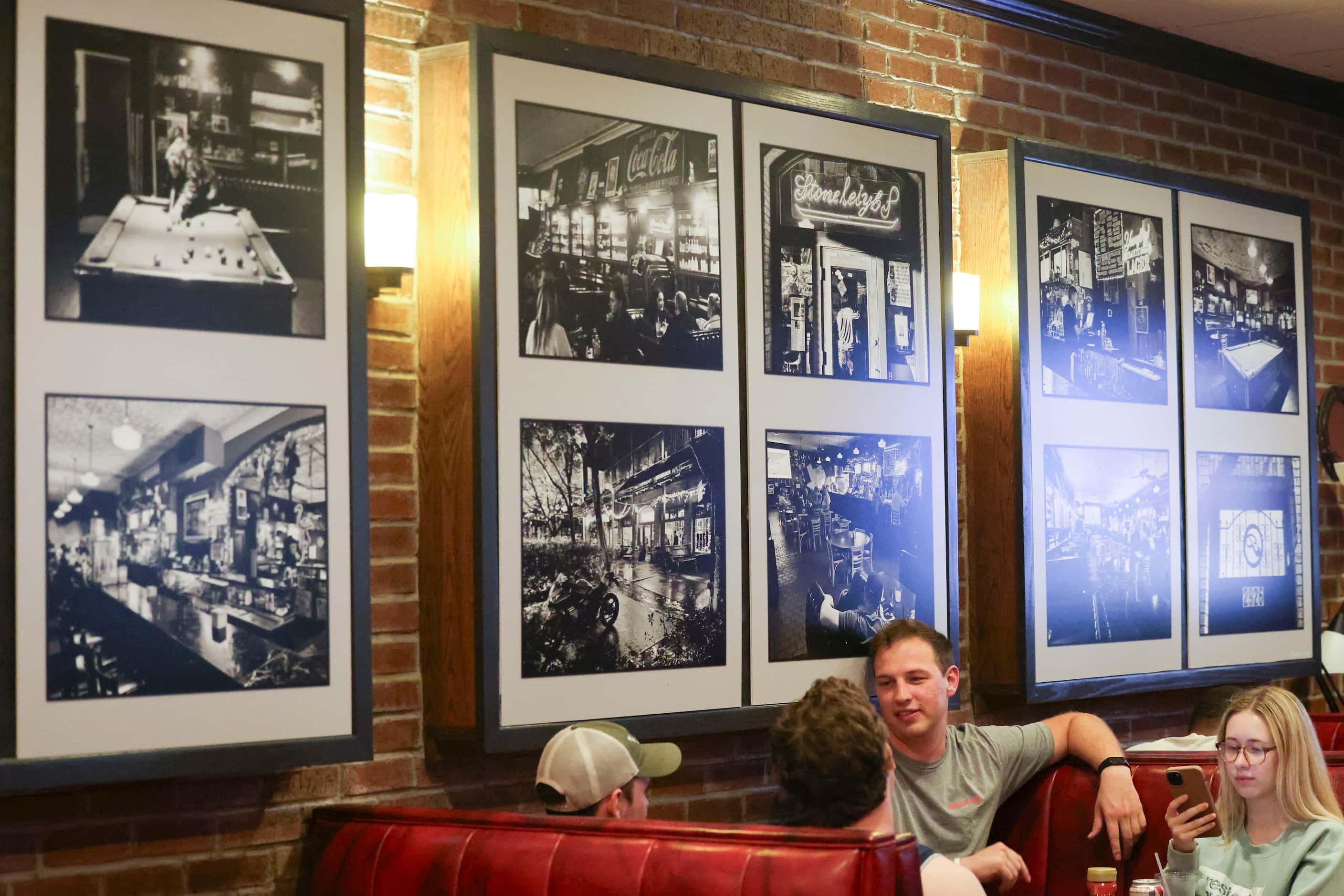 Customers sit beside the black and white photos in the Stoneleigh P that show memories from...