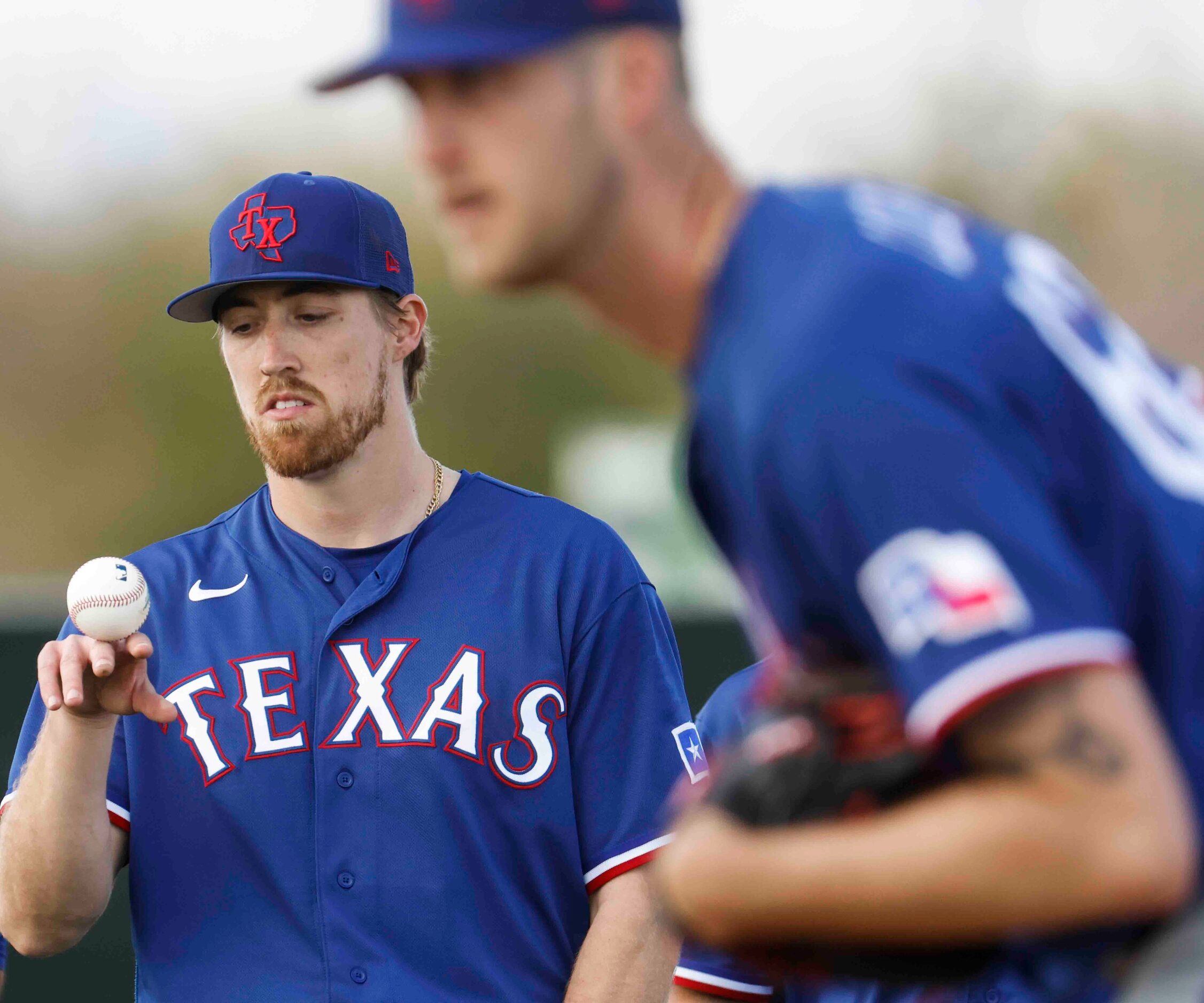 Texas Rangers pitcher Daniel Robert, left, plays with a ball while waiting for his turn...