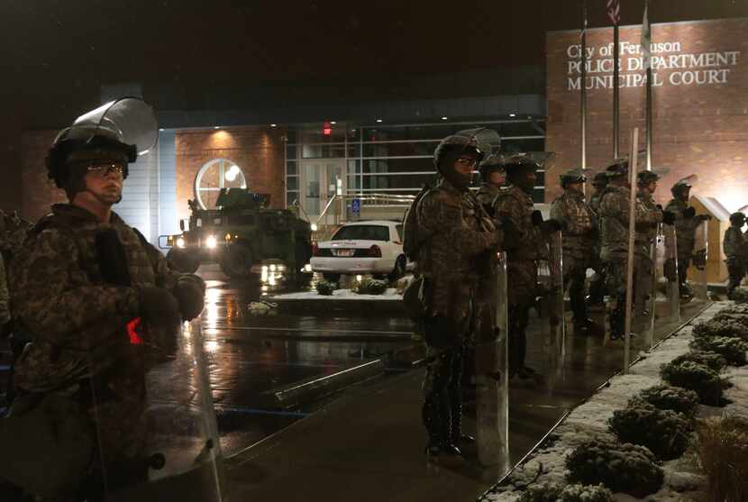 The Missouri National Guard stood in the rain outside the Ferguson Police Station on Wednesday.
