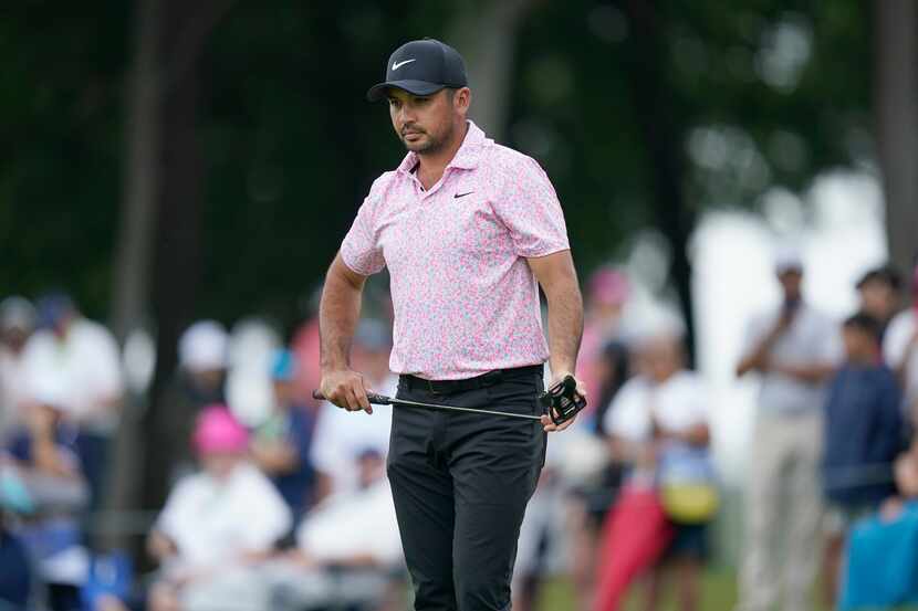 Jason Day, of Australia, looks at his putt line before hitting on the first hole during the...