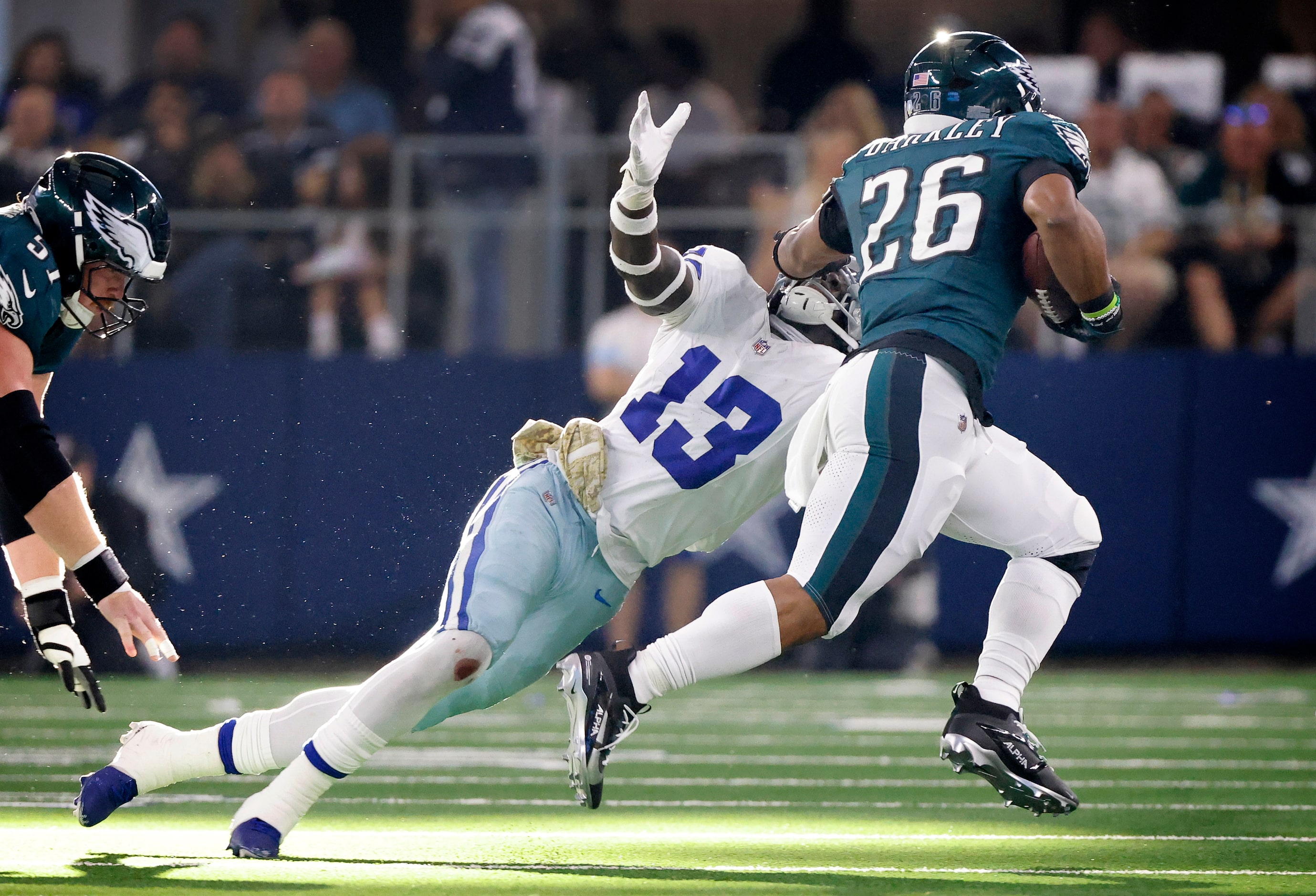 Philadelphia Eagles running back Saquon Barkley (26) gives a stiff arm to Dallas Cowboys...