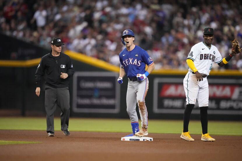 Texas Rangers’ Evan Carter, left, celebrates a double as Arizona Diamondbacks shortstop...