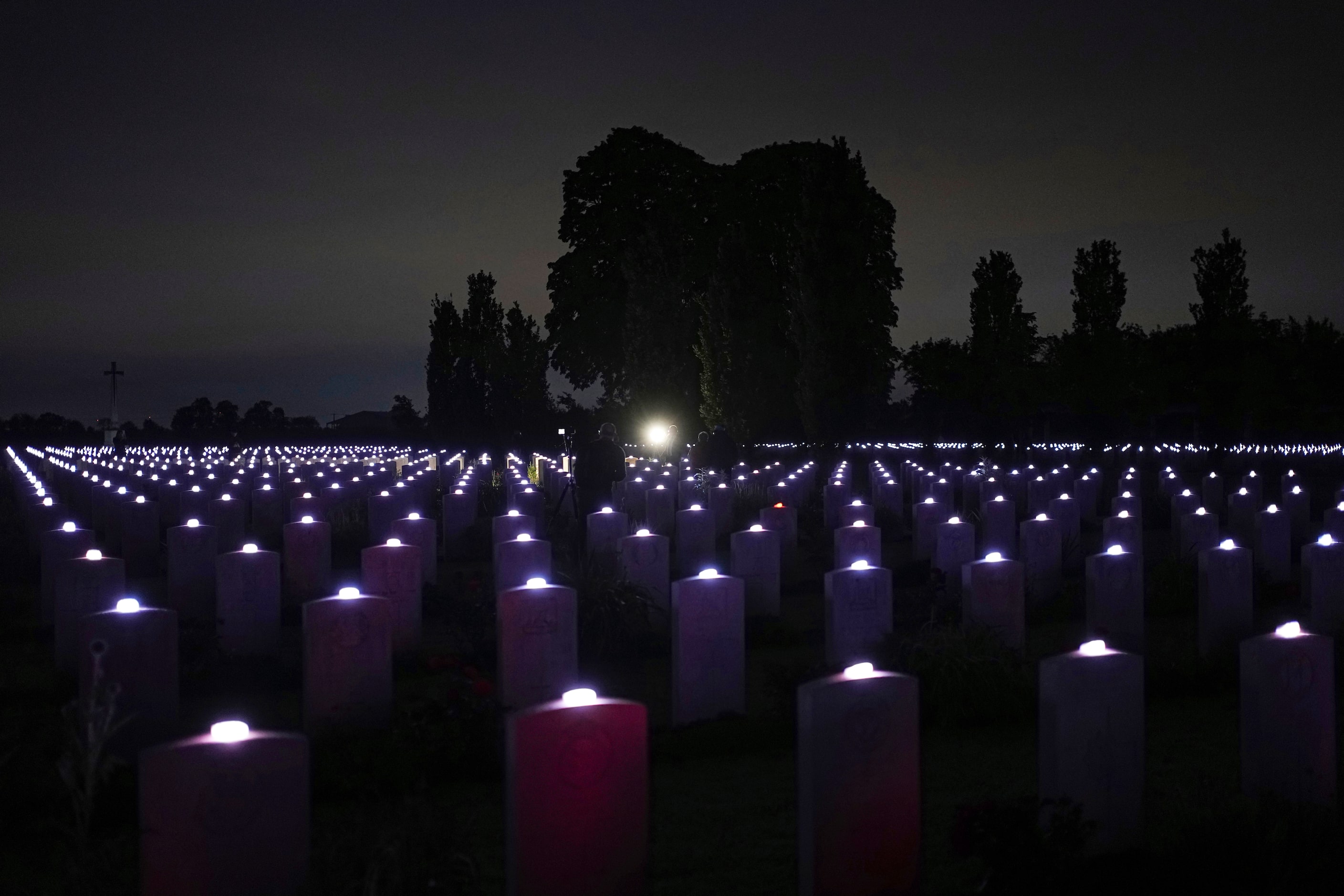 Candles are lit on each tombstone of the Commonwealth war cemetery of...