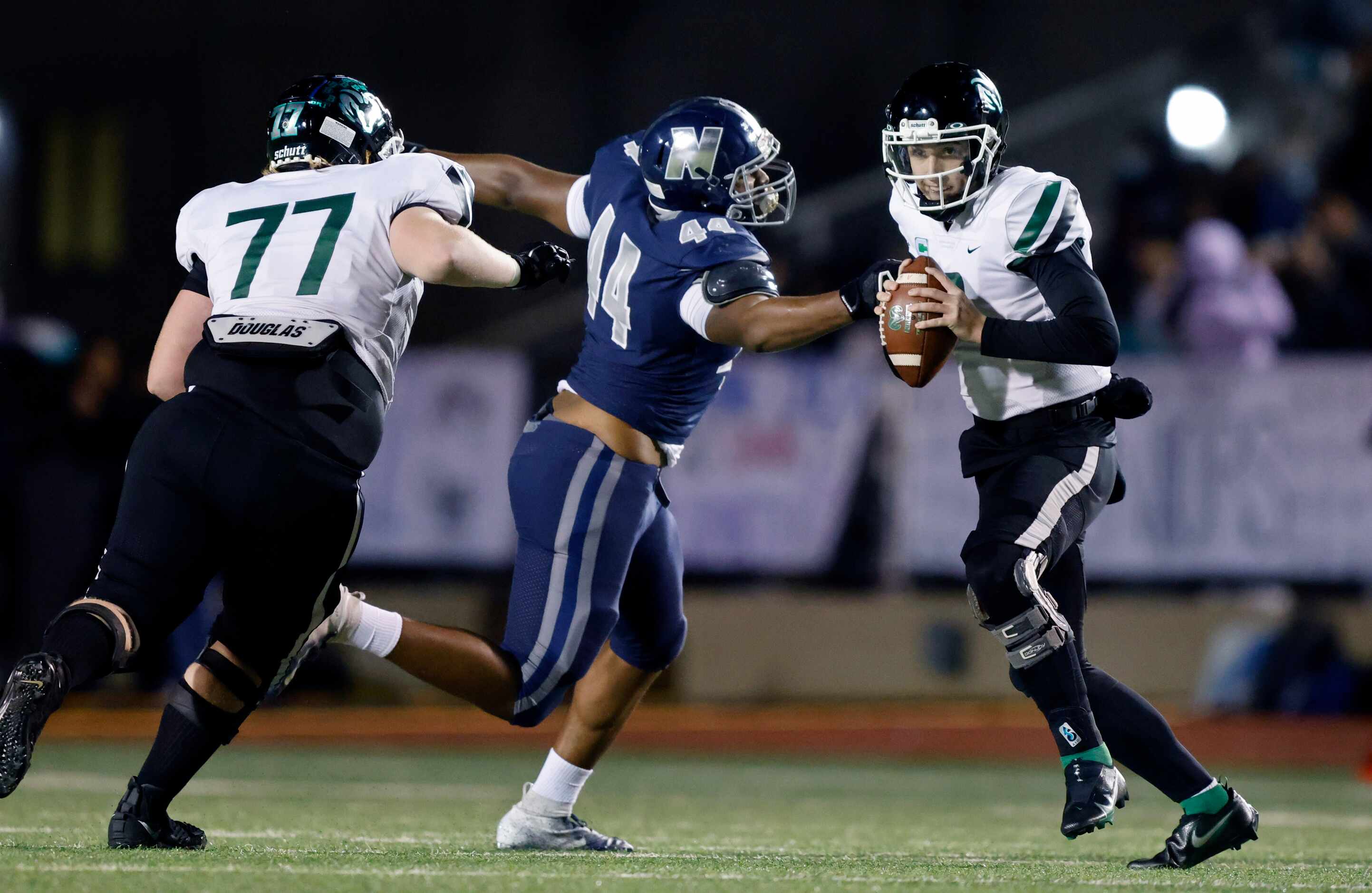 Richardson Berkner quarterback Thomas Landry (8, right) avoids the arm tackle by Irving...