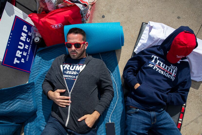 Brandon Stout (left) and his son, Kaden Stout take a brief nap while they camp out in line...