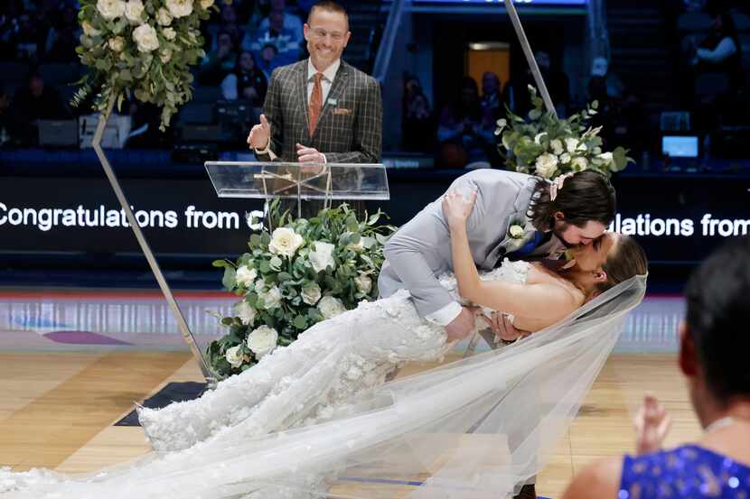Reid Malone dips his bride Ellyn Nichole Piatt after they were wed at halftime on the the...