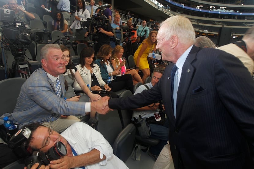 Stephen Jones shakes hands with his father, Dallas Cowboys owner Jerry Jones at AT&T Stadium...