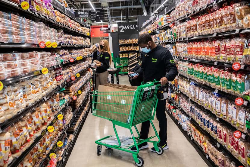 Employees at the Amazon Fresh grocery store in Naperville, Ill., fulfill online orders on...
