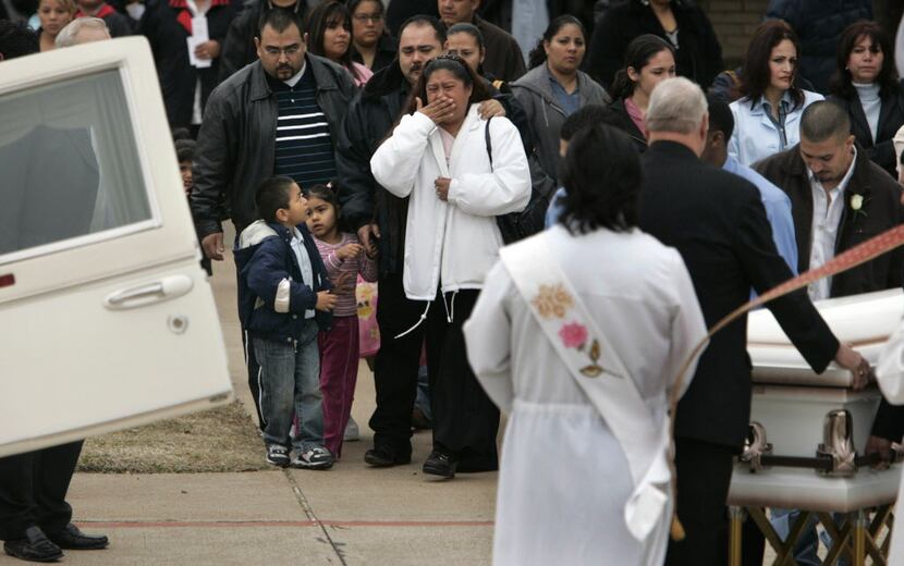 Teodora Ortega de Campos (in white coat), Luis Campos' mother, grieves as the caskets are...