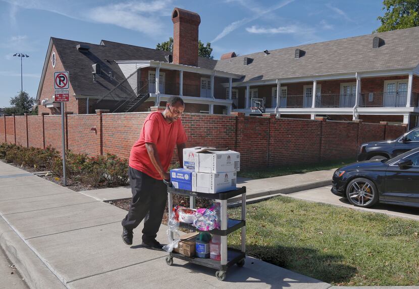 A worker who asked not to be identified removes food items from the Kappa Alpha house on the...
