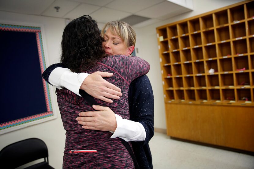 Thomas Jefferson High School principal Sandi Massey (right) receives an emotional hug from...