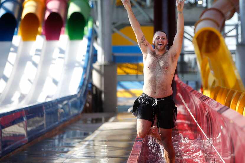 Tyler Hebert celebrates after going down a water slide during a media day at the new Epic...