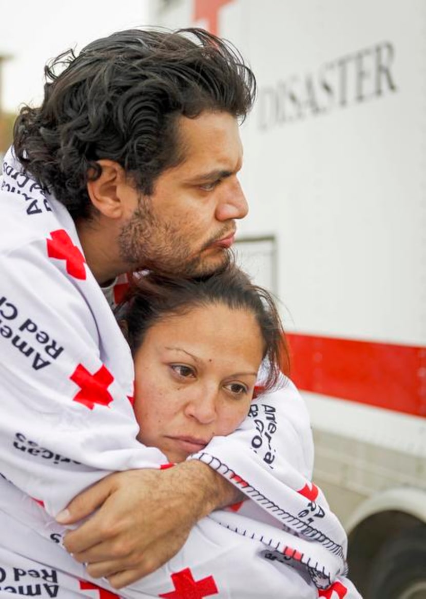 
Adrian Contreras hugged his wife, Lisa, while the pair kept warm in Red Cross blankets...