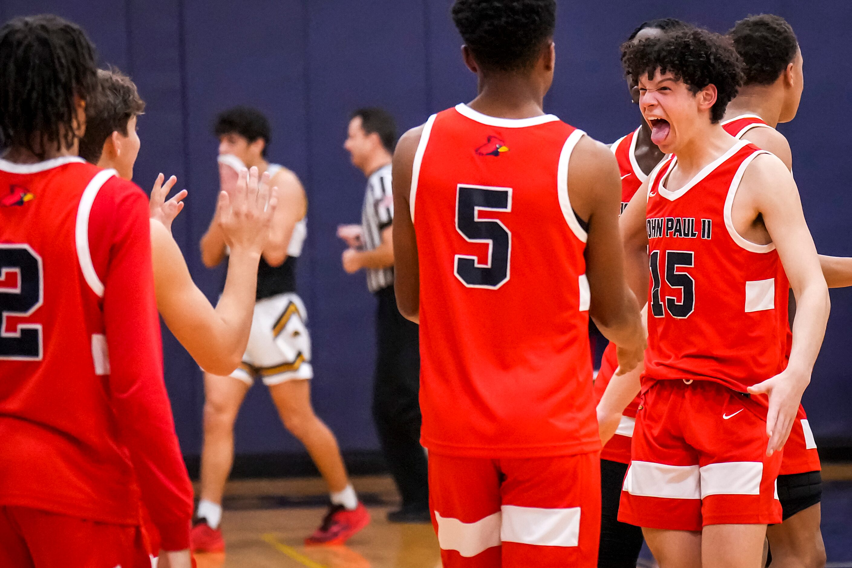 John Paul II's Drew Forkner (15) celebrates with Myles Archibald (5) after a victory over...