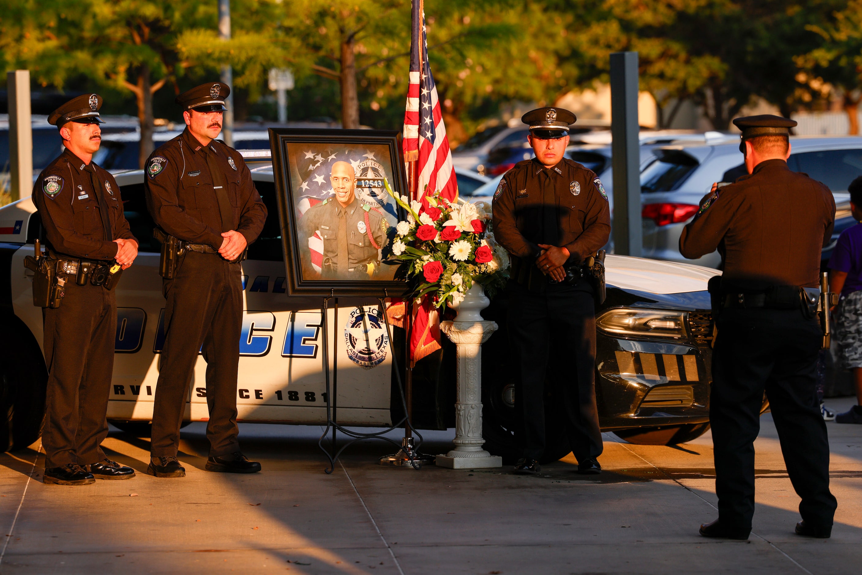 Brownsville police officers pose for a photo during a public visitation for Dallas police...