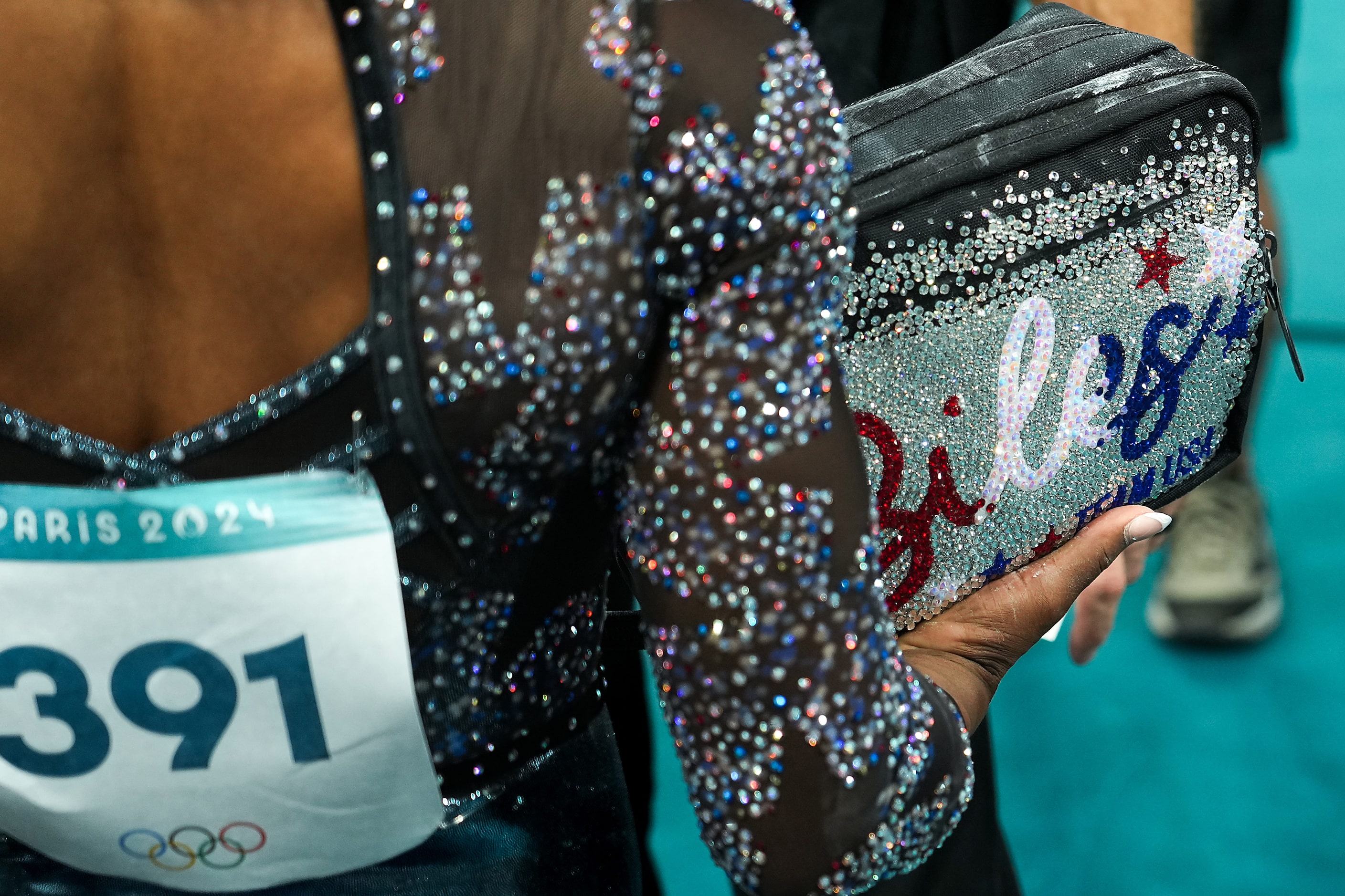 Simone Biles of the United States packs up her equipment after competing on the uneven bars...