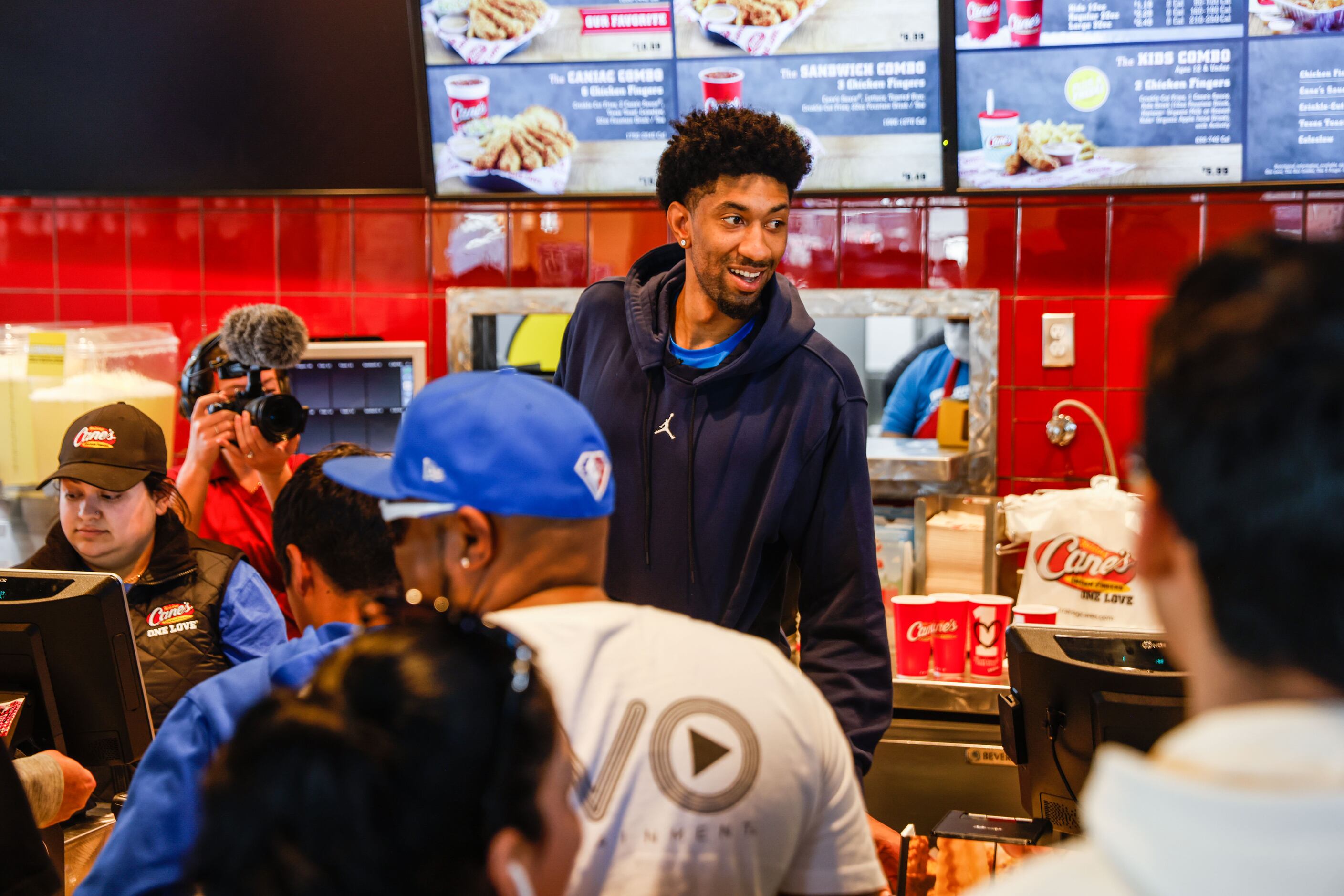 Mavericks player Christian Wood serves lunch at the Raising Cane’s in Dallas on Wednesday,...