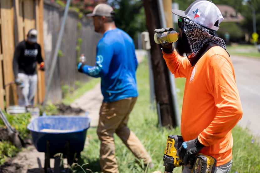 Eduardo Rodriguez (right) takes a short Gatorade break while building a fence at a home in...