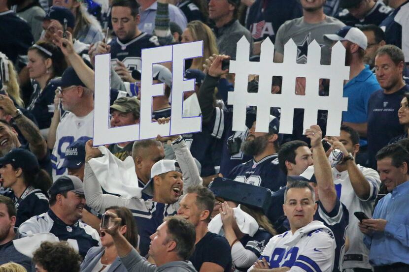 Dallas fans hold signs extolling the greatness of Dallas Cowboys outside linebacker Sean Lee...