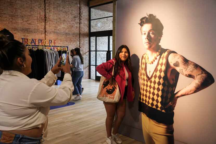Itzel Ramirez poses next to a photo of Harry Styles on Friday at the Harry's House pop-up...