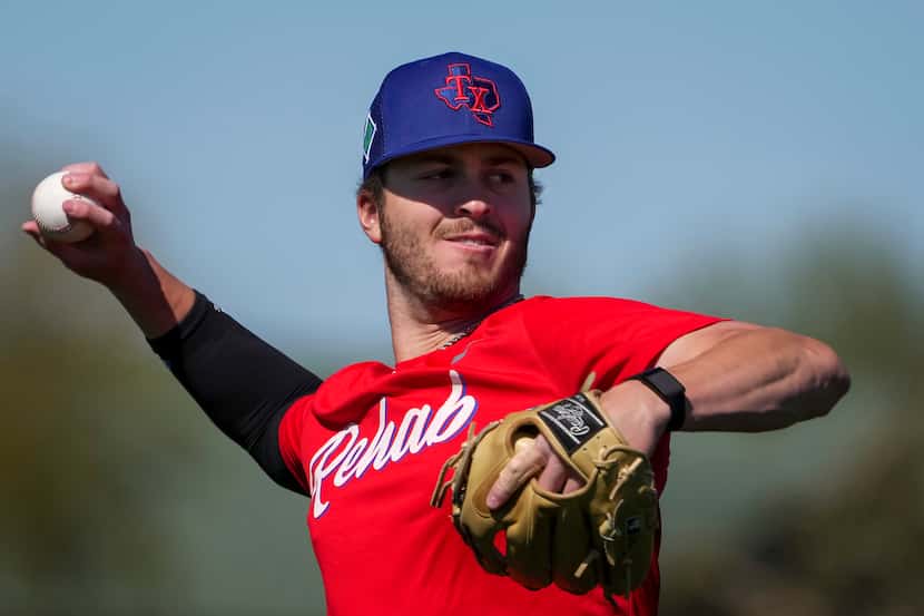 Pitcher Dane Acker throws during a Texas Rangers minor league spring camp workout at the...