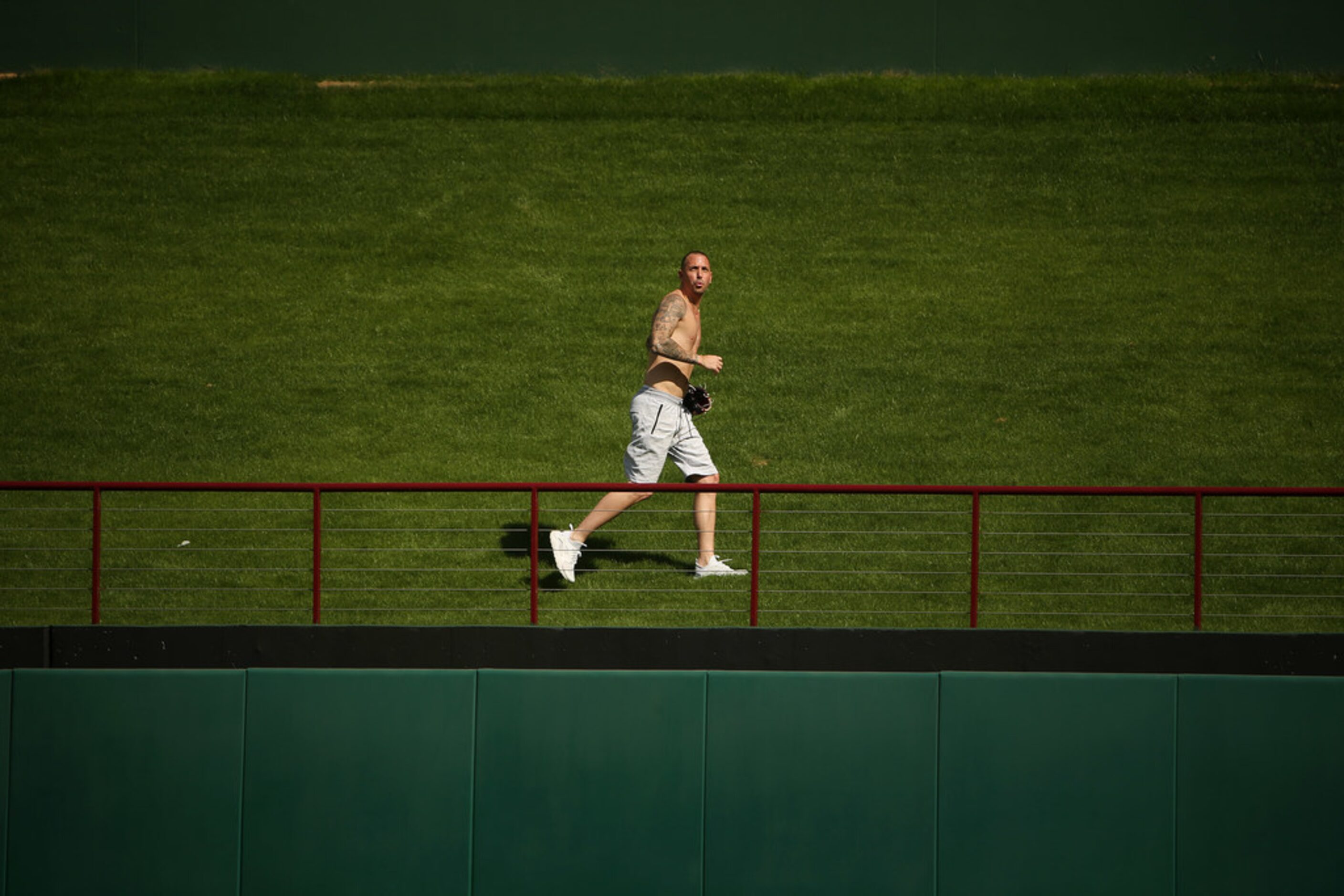 A fan runs for a ball in center field during batting practice before a Major League Baseball...