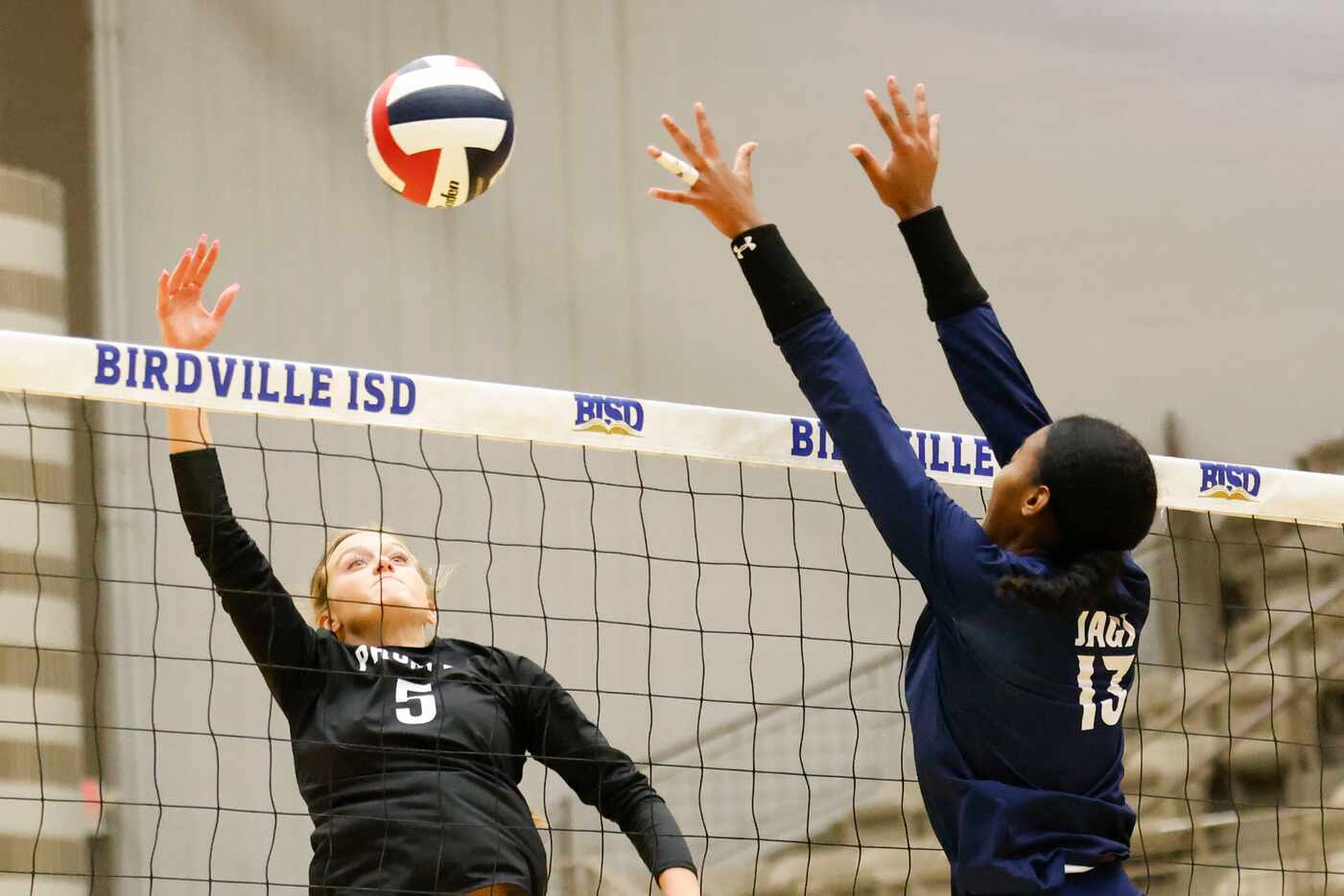 Prosper high’s Sydney Thornton (left) spikes the ball against Flower Mound high’s Brianna...