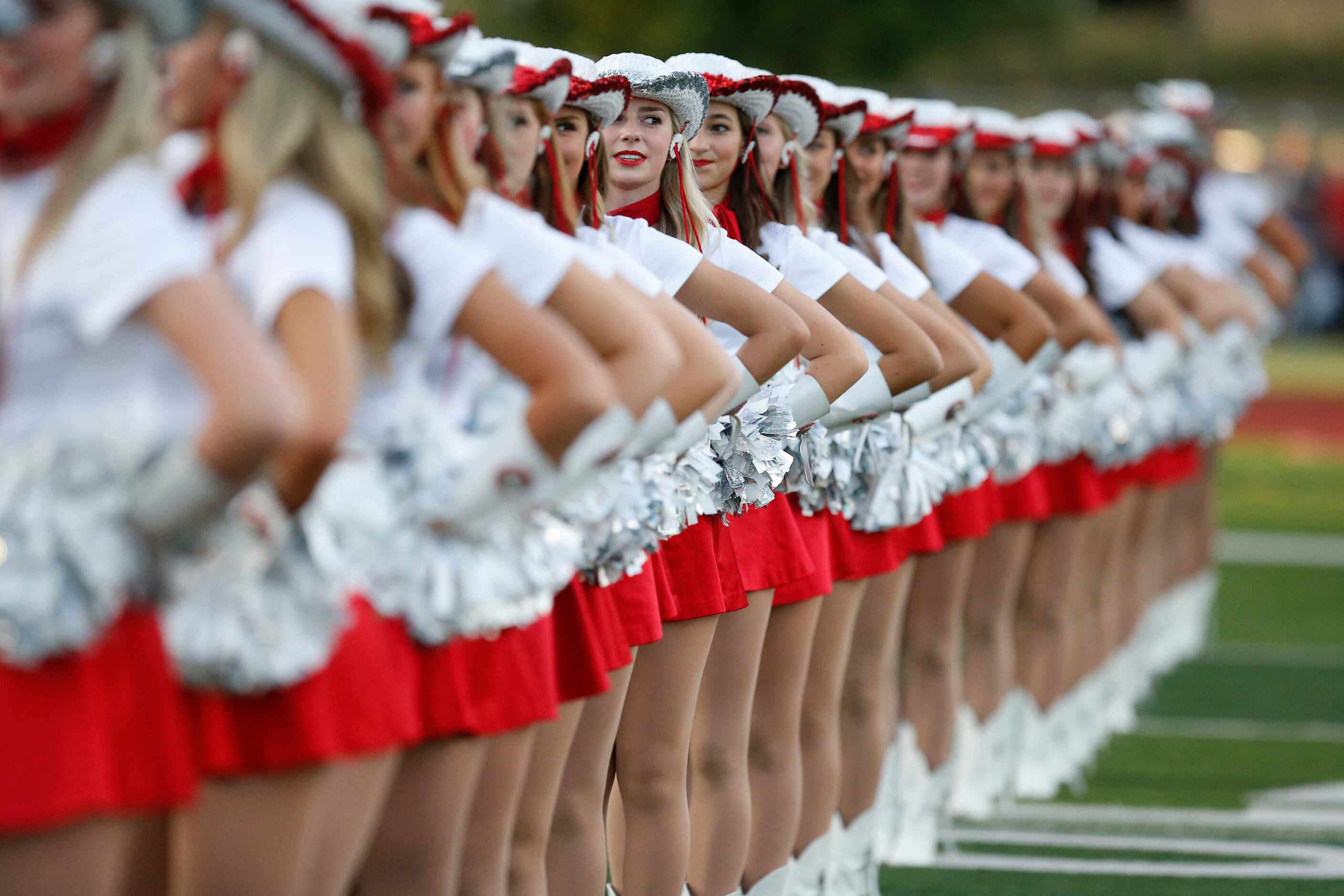 The Flower Mound Marcus High School Marquettes drill team stand at attention before kickoff...