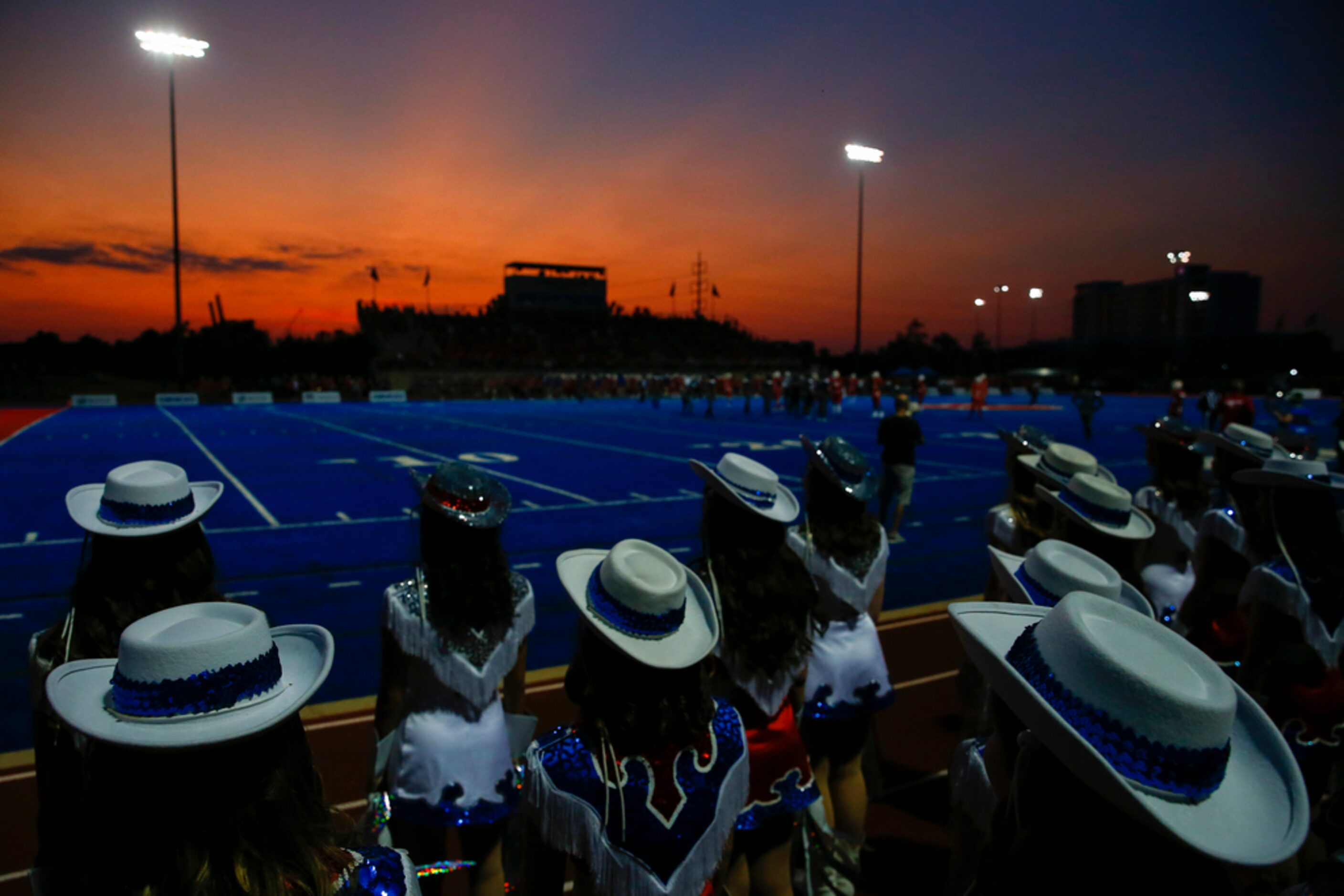 The sun sets over a high school football game between Parish Episcopal and Trinity...